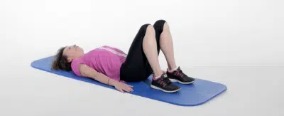 Jeune femme allongee sur son dos faisant des exercices sur tapis de gym - musculation - gainage | Dr Jerome Auger Paris 16