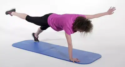 Jeune femme faisant des exercices sur tapis de gym - musculation - gainage | Dr Jerome Auger Paris 16